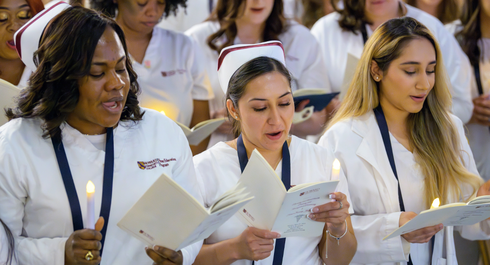 Three Nursing Students reciting the nursing oath at the Nursing Pinning Ceremony