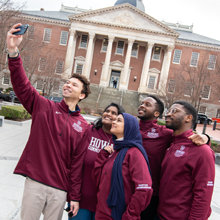 Students taking a selfie in front of building