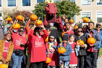 Students with pumpkins and the dragon on the quad