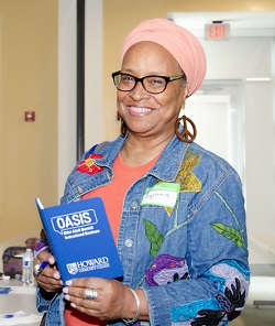 Woman smiling holding an oasis booklet