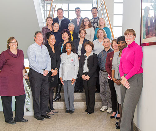 Group of adults posed together on stairs at howard community college