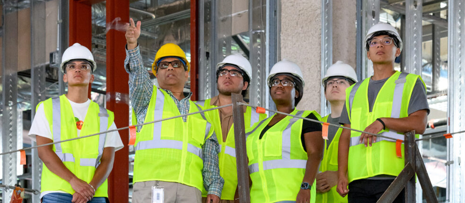 Apprentices with hard hats and safety vests in a construction setting