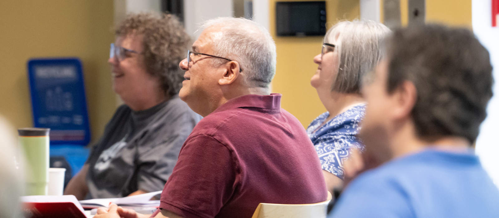 Participants at the OASIS Older Adult Summit listen and smile during an instructional seminar.