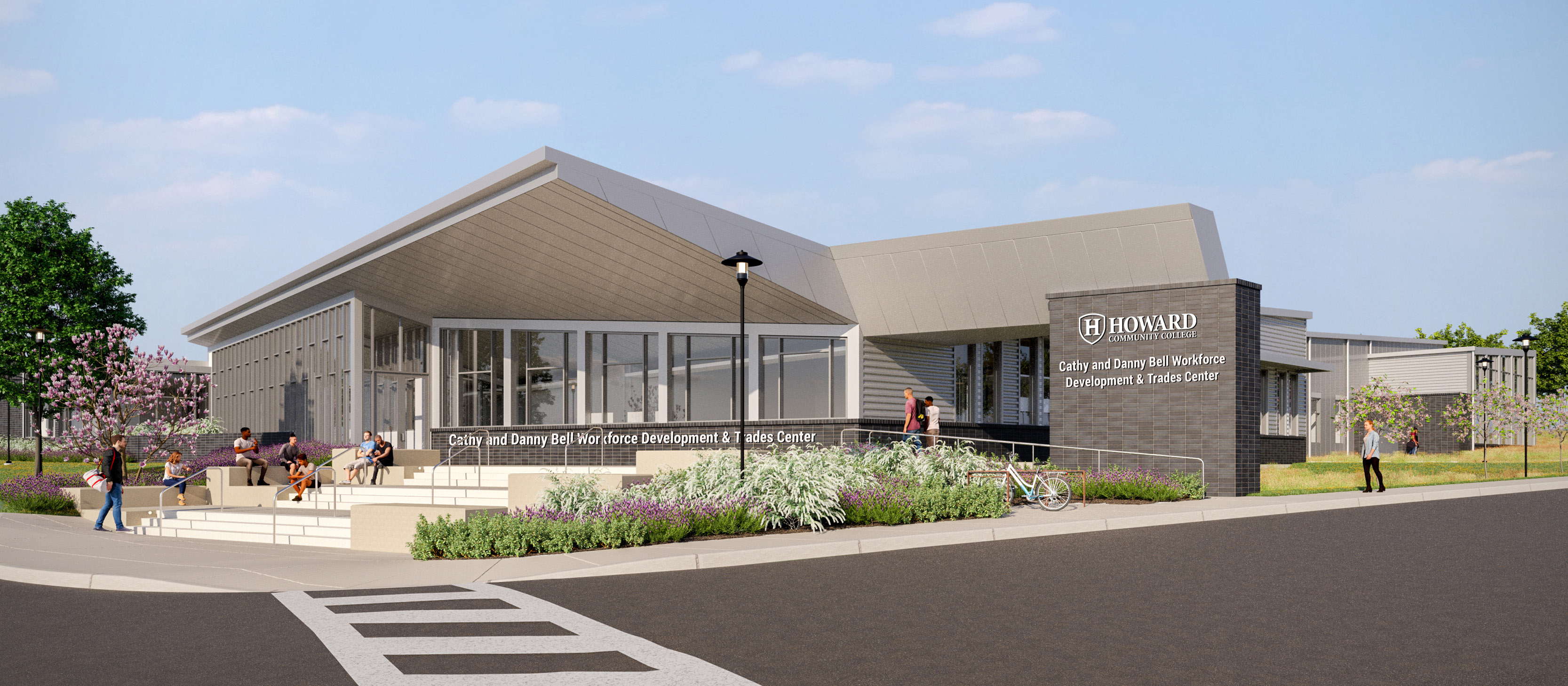 Architectural rendering of the Cathy and Danny Bell Workforce Development & Trades Center at Howard Community College. The modern building features large windows, angular rooflines, and landscaped walkways with students sitting and walking outside under a clear sky.