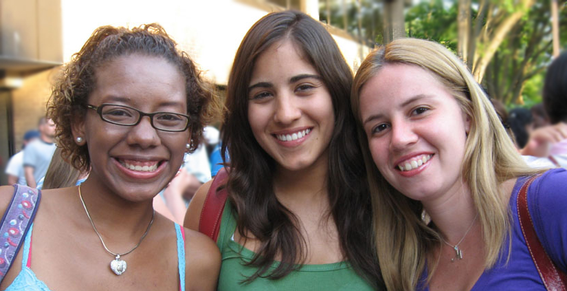 Three young women smiling together outdoors