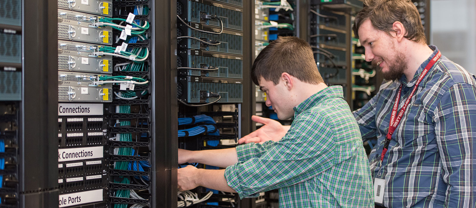 Student and instructor working at a rack of IT equipment