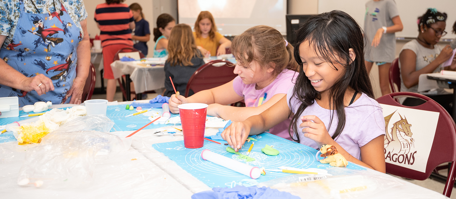 Young students sitting at tables doing crafts