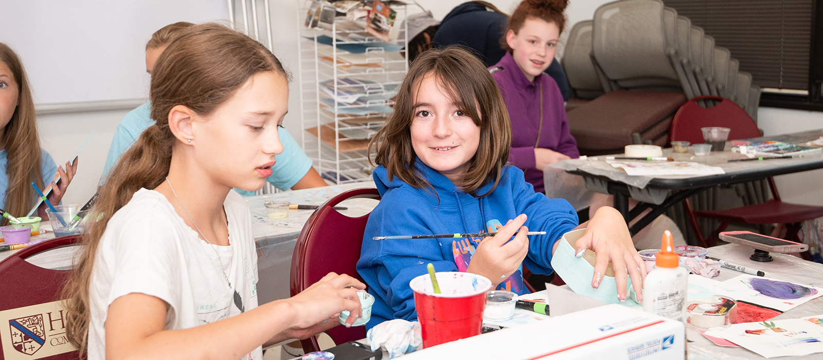 Young students sitting at tables doing crafts