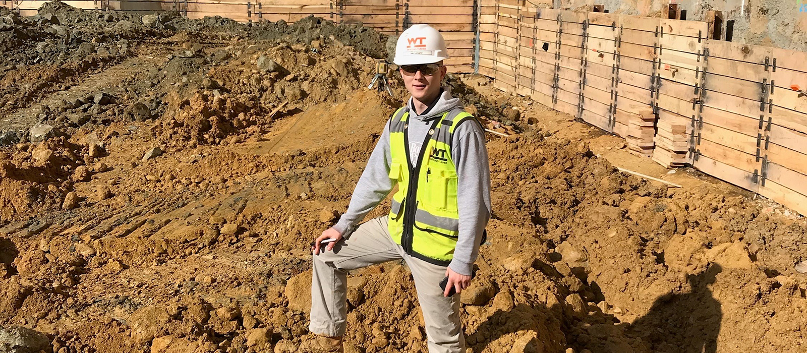 Person wearing a hard had and yellow vest standing on a construction site