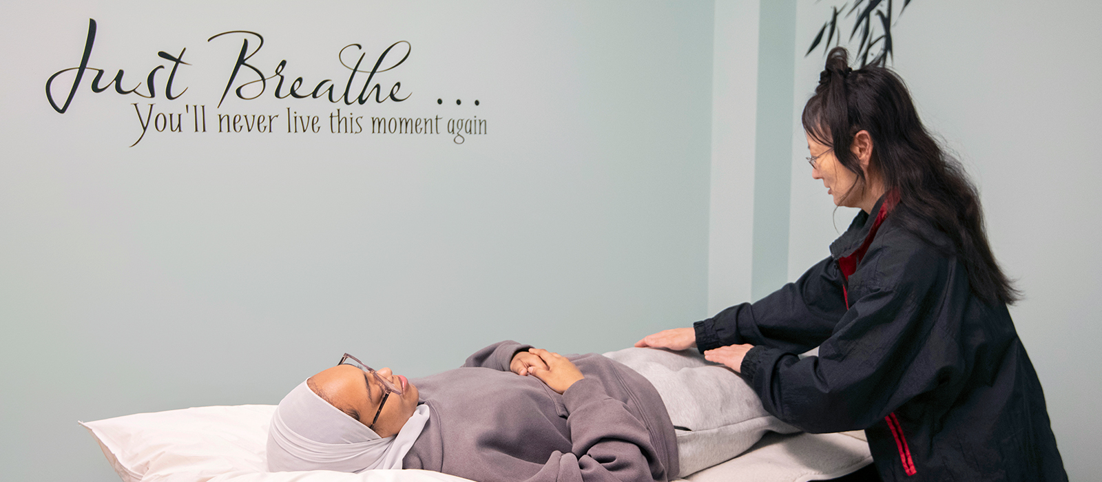 A student receiving Reiki treatment by a practitioner in a Wellness Room.