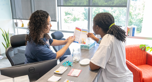 Staff member assists a student with resources at the Student Life services desk.