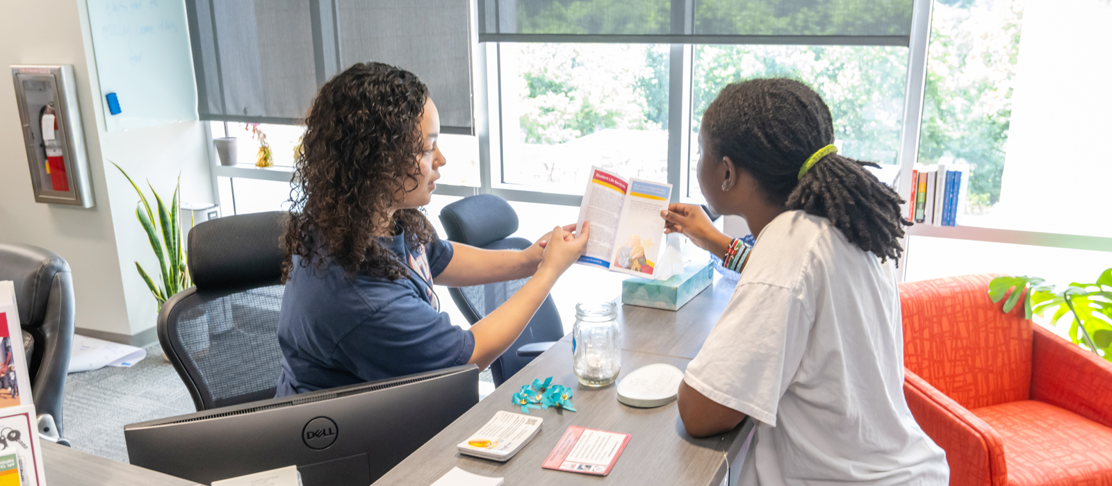 Staff member assists a student with resources at the Student Life services desk.